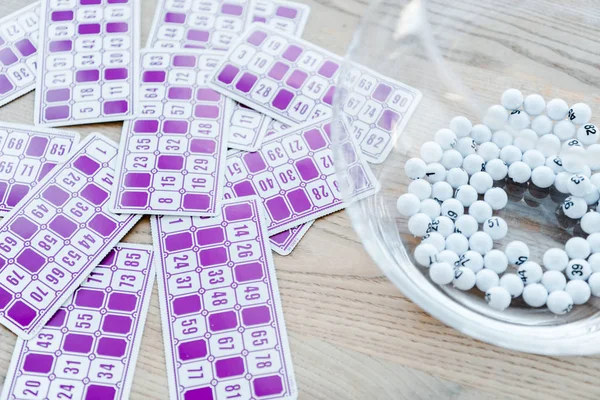 Billetes de lotería púrpura con números cerca de cuenco con bolas - foto de stock