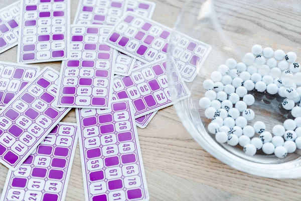 Purple lottery tickets with numbers near bowl with balls — Stock Photo