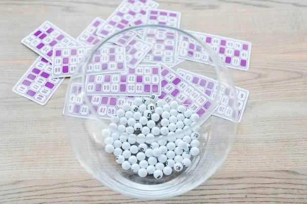 Selective focus of glass bowl with balls near purple lottery tickets — Stock Photo