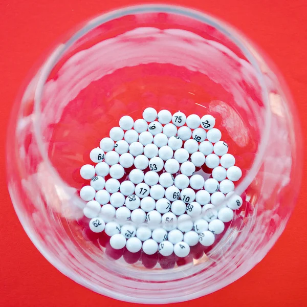 Close up of bowl with balls near lottery tickets isolated on red — Stock Photo