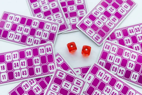 Vista superior de los dados rojos cerca de billetes de lotería aislados en blanco - foto de stock