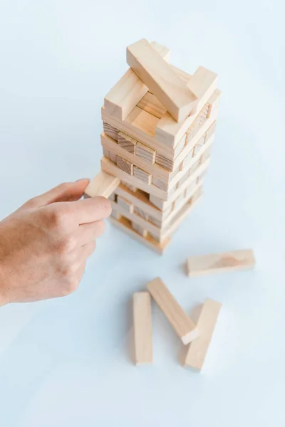 QUIIV, UCRÂNIA - NOVEMBRO 22, 2019: visão cortada do homem jogando blocos de madeira jogo isolado em branco — Fotografia de Stock