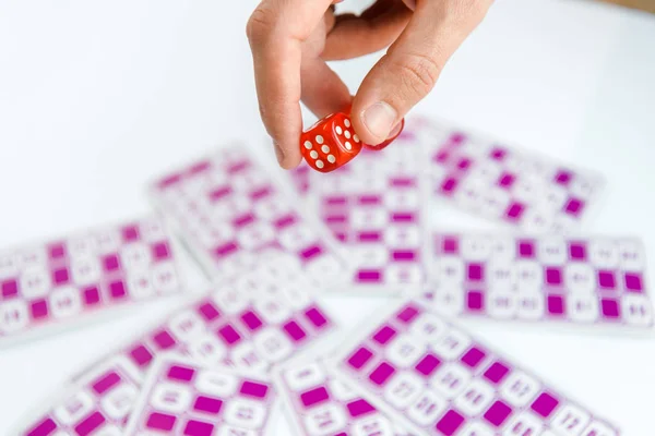 Обрізаний вид людини, що тримає червоні кубики біля лотерейних квитків ізольовані на білому — стокове фото