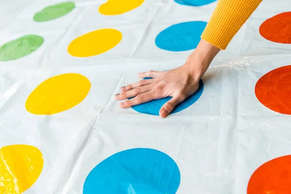 KYIV, UKRAINE - NOVEMBER 22, 2019: cropped view of woman putting hand on blue circle while playing twister game — Stock Photo