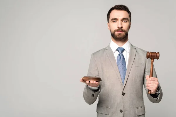 Confident judge holding gavel while looking at camera isolated on grey — Stock Photo