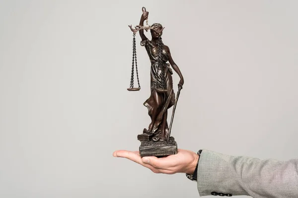 Partial view of lawyer holding themis statue isolated on grey — Stock Photo