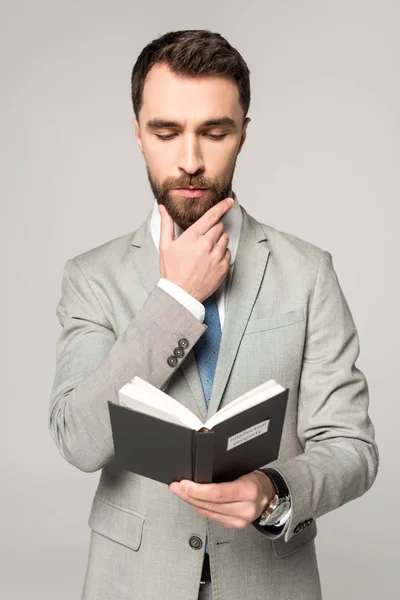 Aufmerksamer Geschäftsmann liest Buch mit geistigem Eigentum Titel isoliert auf grau — Stockfoto