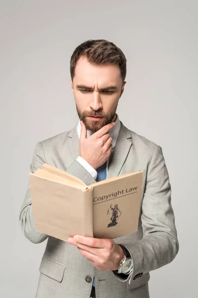 Серьезный адвокат чтение книги с авторским правом название изолированы на серый — стоковое фото