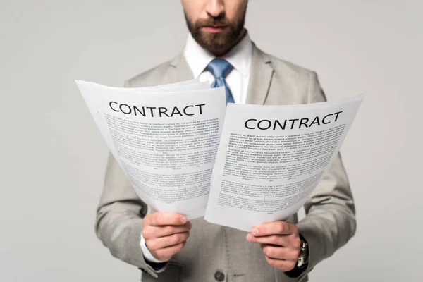 Vista recortada de los contratos de lectura de hombres de negocios aislados en gris - foto de stock