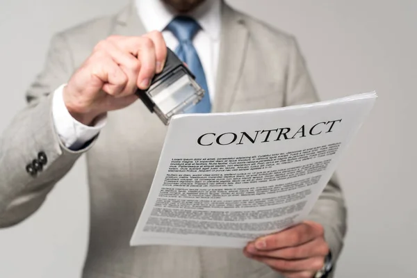 Обрезанный взгляд бизнесмена поставить штамп на контракт изолированы на серый — стоковое фото