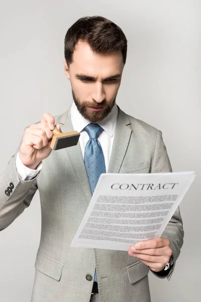 Serious lawyer putting stamp on contract isolated on grey — Stock Photo