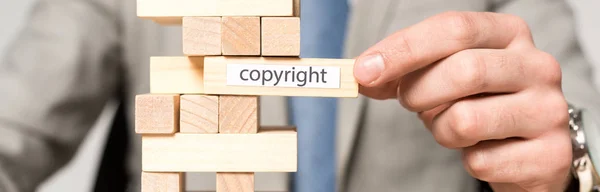 Частковий вид на бізнесмена біля блоків дерев'яна вежа гра з авторським написом ізольовано на сірому — стокове фото