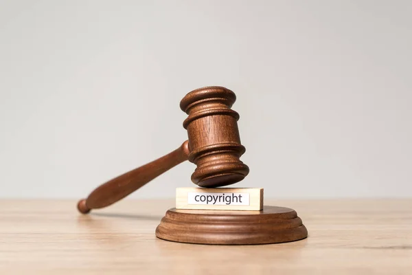 Gavel and wooden block with copyright inscription on wooden desk isolated on grey — Stock Photo