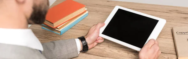Частковий вид бізнесмена, що тримає цифровий планшет з порожнім екраном ізольовано в сірому, панорамному пострілі — стокове фото