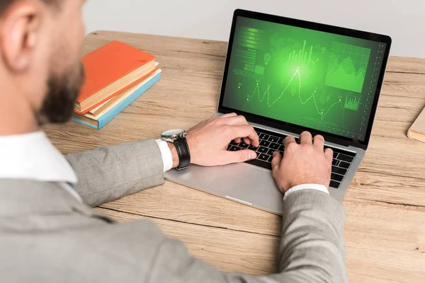 Vue partielle de l'homme d'affaires à l'aide d'un ordinateur portable avec des informations marketing à l'écran isolé sur gris — Stock Photo