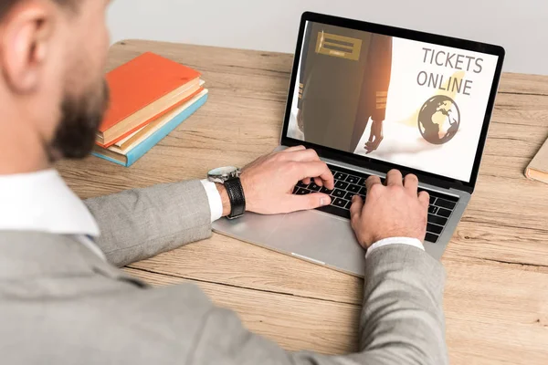 Vista recortada de hombre de negocios utilizando el ordenador portátil con entradas sitio web en línea en la pantalla aislada en gris - foto de stock