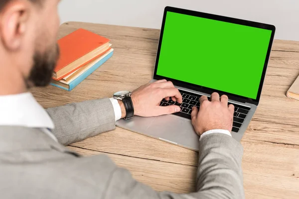 Vista ritagliata di uomo d'affari utilizzando laptop con schermo bianco verde isolato su grigio — Foto stock