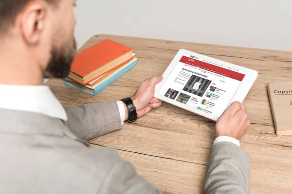 KYIV, UKRAINE - NOVEMBER 25, 2019: cropped view of businessman using digital tablet with BBC News app on screen isolated on grey — Stock Photo