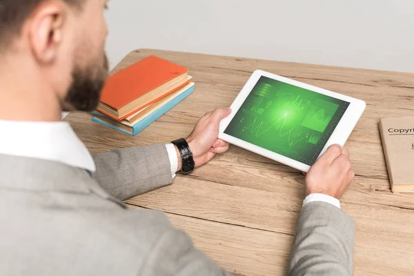 Vista parcial del empresario utilizando tableta digital con infografías de marketing en pantalla aislada en gris - foto de stock