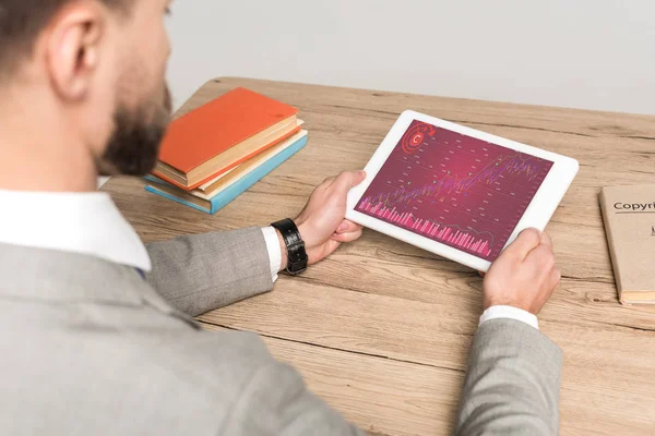 Vista recortada de hombre de negocios utilizando tableta digital con gráficos y gráficos en pantalla aislada en gris - foto de stock