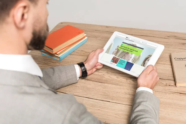 KYIV, UKRAINE - NOVEMBER 25, 2019: cropped view of businessman using digital tablet with BBC News app on screen isolated on grey — Stock Photo