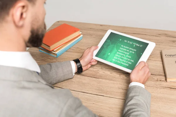 Vista recortada de hombre de negocios utilizando tableta digital con aplicación médica en la pantalla aislada en gris - foto de stock