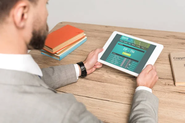 Ausgeschnittene Ansicht des Geschäftsmannes mit digitalem Tablet mit Sportwetten-Website auf dem Bildschirm isoliert auf grau — Stockfoto