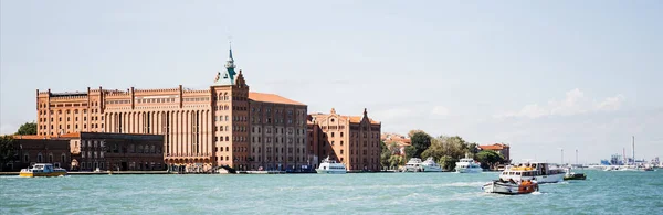 Plano panorámico de vaporettos flotantes cerca de edificios antiguos en Venecia, Italia - foto de stock