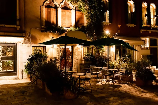 Café extérieur avec chaises et tables la nuit à Venise, Italie — Photo de stock