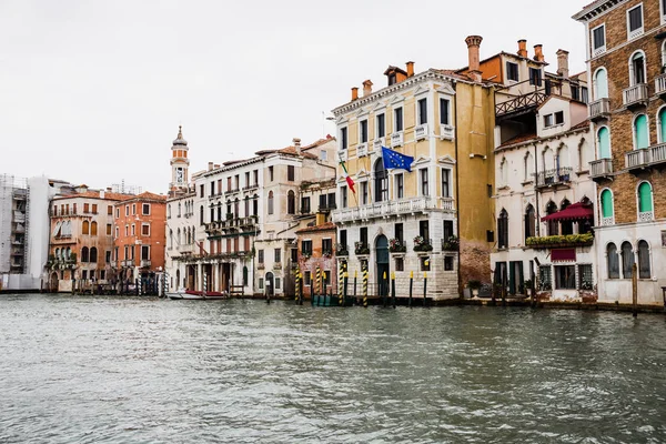 Canal and ancient buildings with flags in Venice, Italy — Stock Photo