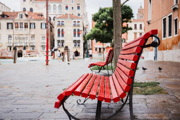 Selective focus of red bench and ancient buildings on background in Venice, Italy — Stock Photo