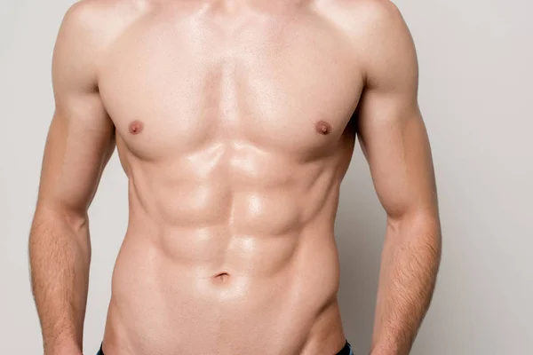 Cropped view of sexy man with muscular torso isolated on grey — Stock Photo