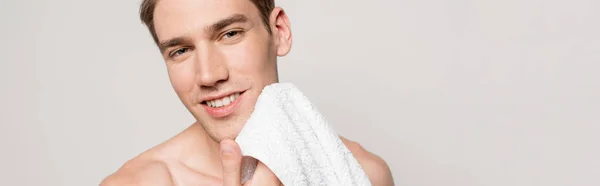 Sorrindo homem sexy com tronco muscular segurando toalha de algodão isolado em cinza, tiro panorâmico — Fotografia de Stock