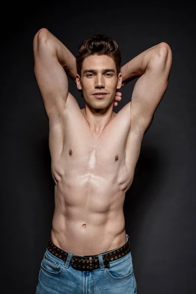 Sexy joven con torso muscular posando sobre fondo negro - foto de stock