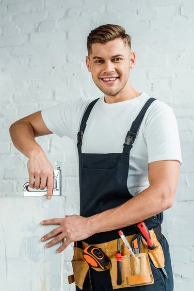 Щасливий монтажник тримає будівельний степлер біля фарбування — стокове фото