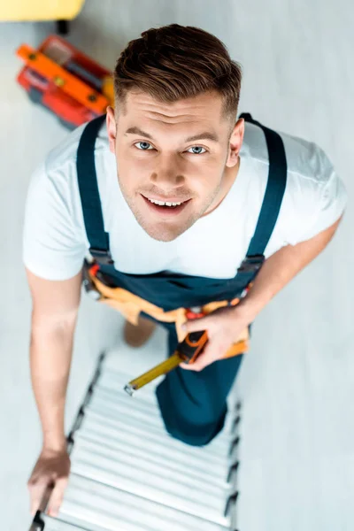 Vista superior da escada de escalada instalador feliz e olhando para a câmera — Fotografia de Stock