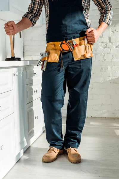 Обрезанный вид монтажника, стоящего с сжатым кулаком и держащего сантехника — стоковое фото