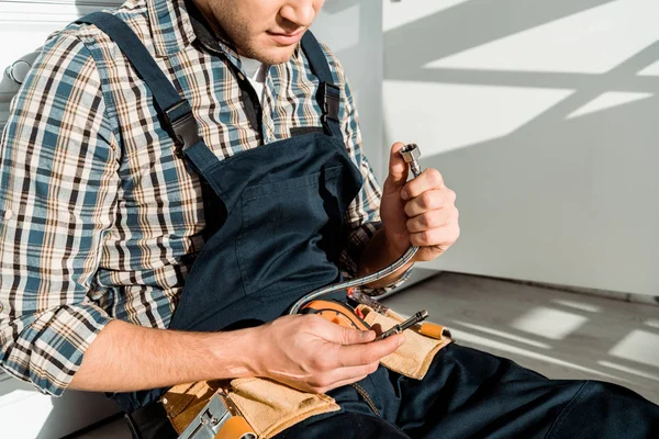 Cropped view of installer holding metal hose — Stock Photo