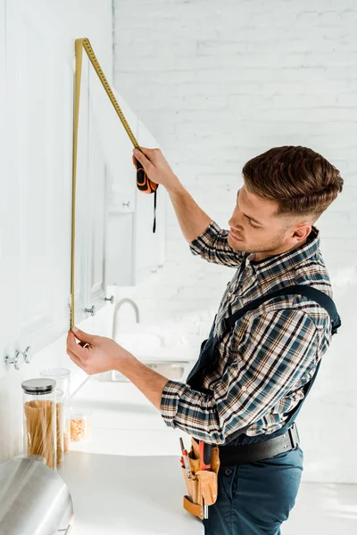 Installateur in Overalls mit weißem Küchenschrank — Stockfoto