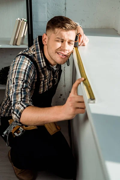 Mise au point sélective de l'installateur mesurant le rebord de la fenêtre tout en maintenant le ruban — Photo de stock