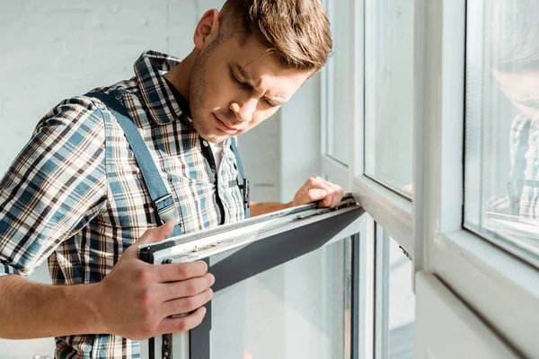 Enfoque selectivo del instalador guapo tocando ventana - foto de stock