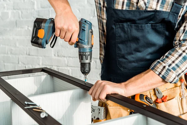 Vue recadrée de l'installateur tenant marteau perceuse près de rack — Photo de stock