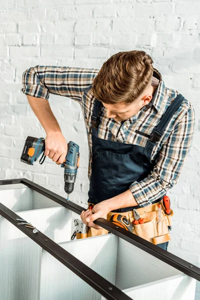 Instalador focado segurando broca de martelo enquanto instala rack — Fotografia de Stock