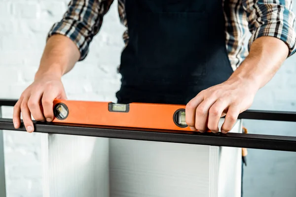 Cropped view of installer holding building level — Stock Photo