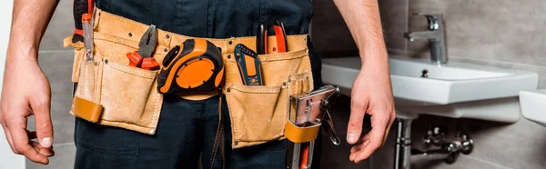 Panoramic shot of installer with tool belt — Stock Photo