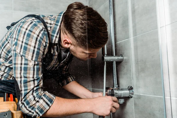 Installateur toucher tuyau métallique dans la salle de bain — Photo de stock