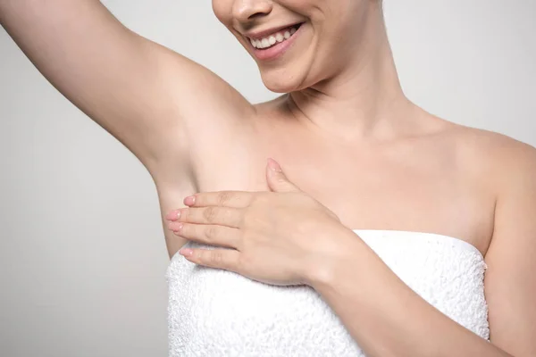 Cropped view of smiling woman touching underarm isolated on grey — Stock Photo