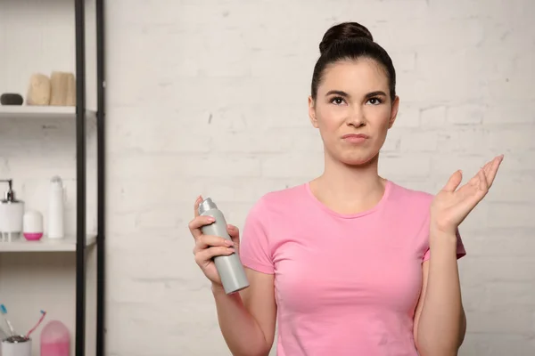 Mujer insatisfecha agitando la mano mientras sostiene el desodorante - foto de stock