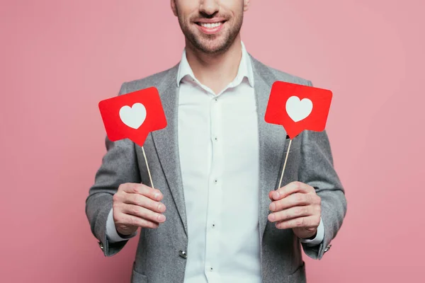 Vista recortada del hombre sonriente sosteniendo tarjetas con corazones para el día de San Valentín, aislado en rosa - foto de stock