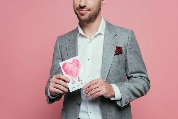 Cropped view of man holding valentines day card with heart, isolated on pink — Stock Photo